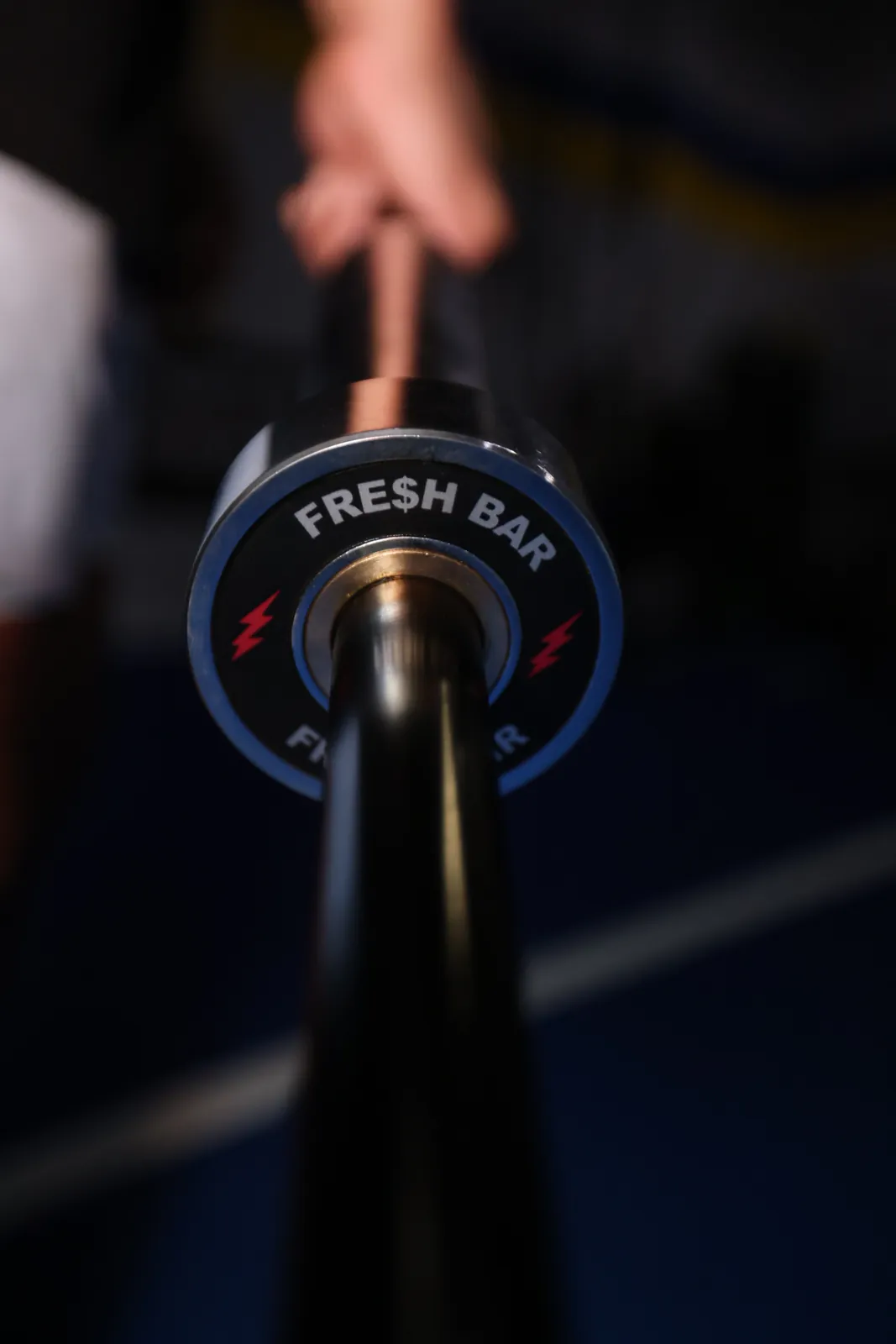 A hand holding the Fresh Bar by its loadable end on blue turf.