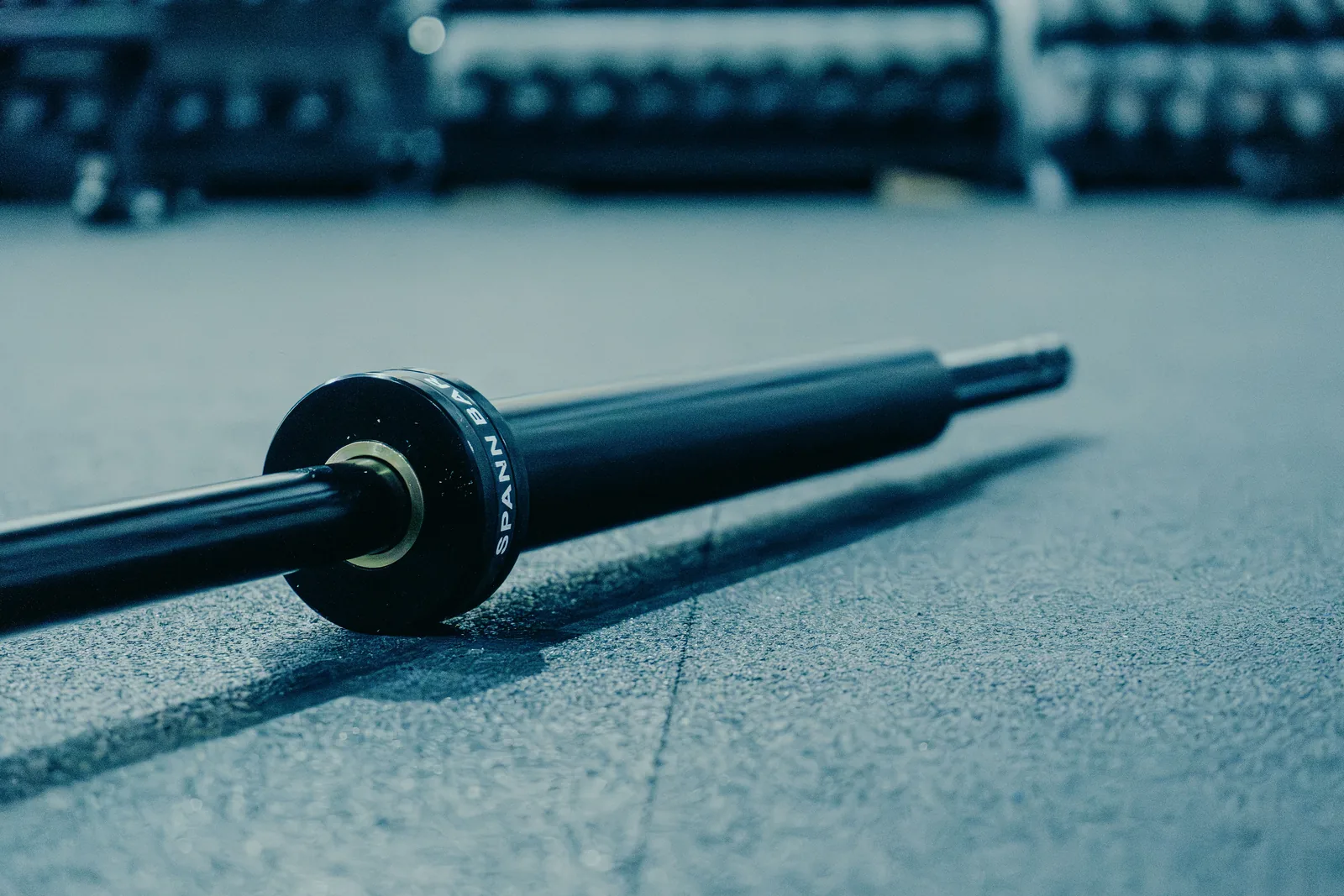 The Spann Bar on the gym floor, its black SPANN BAR collar toward the camera.