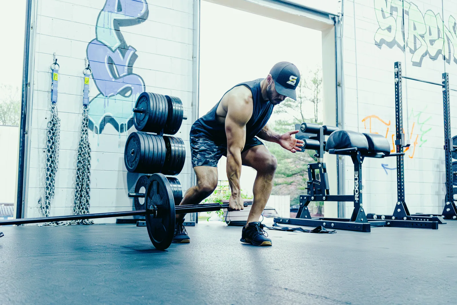 An athlete setting up a single-arm landmine deadlift with the loaded Spann Bar.