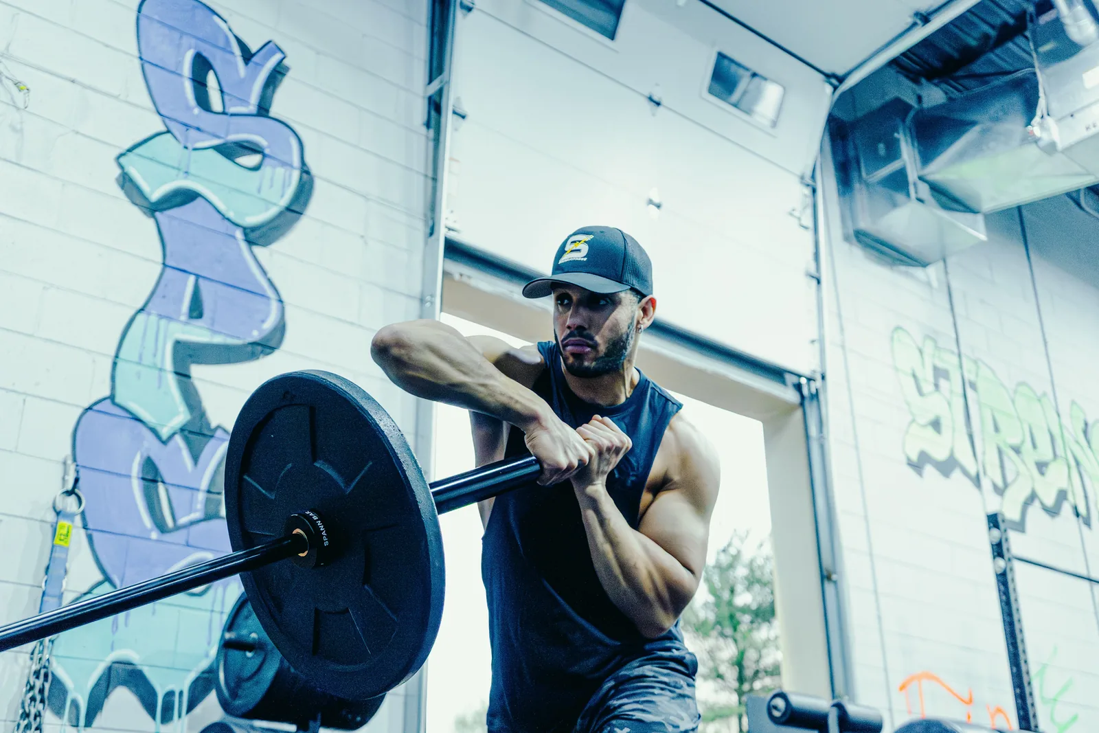 An athlete pressing the loaded Spann Bar from his chest, the black collar beside the plate.