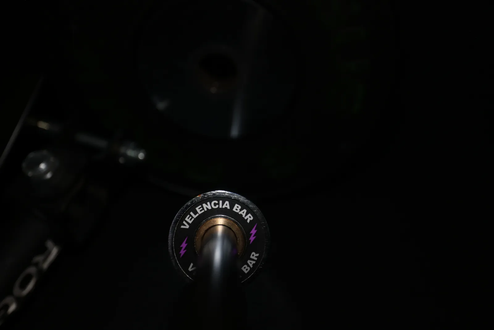 The Velencia Bar end cap, purple bolts, in the rack beside a Rogue plate.