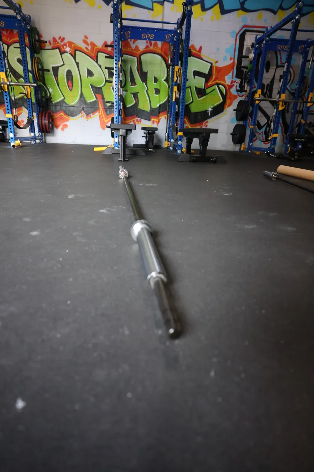 The Velencia Bar from the knurled grip end, pointed at a graffiti wall.