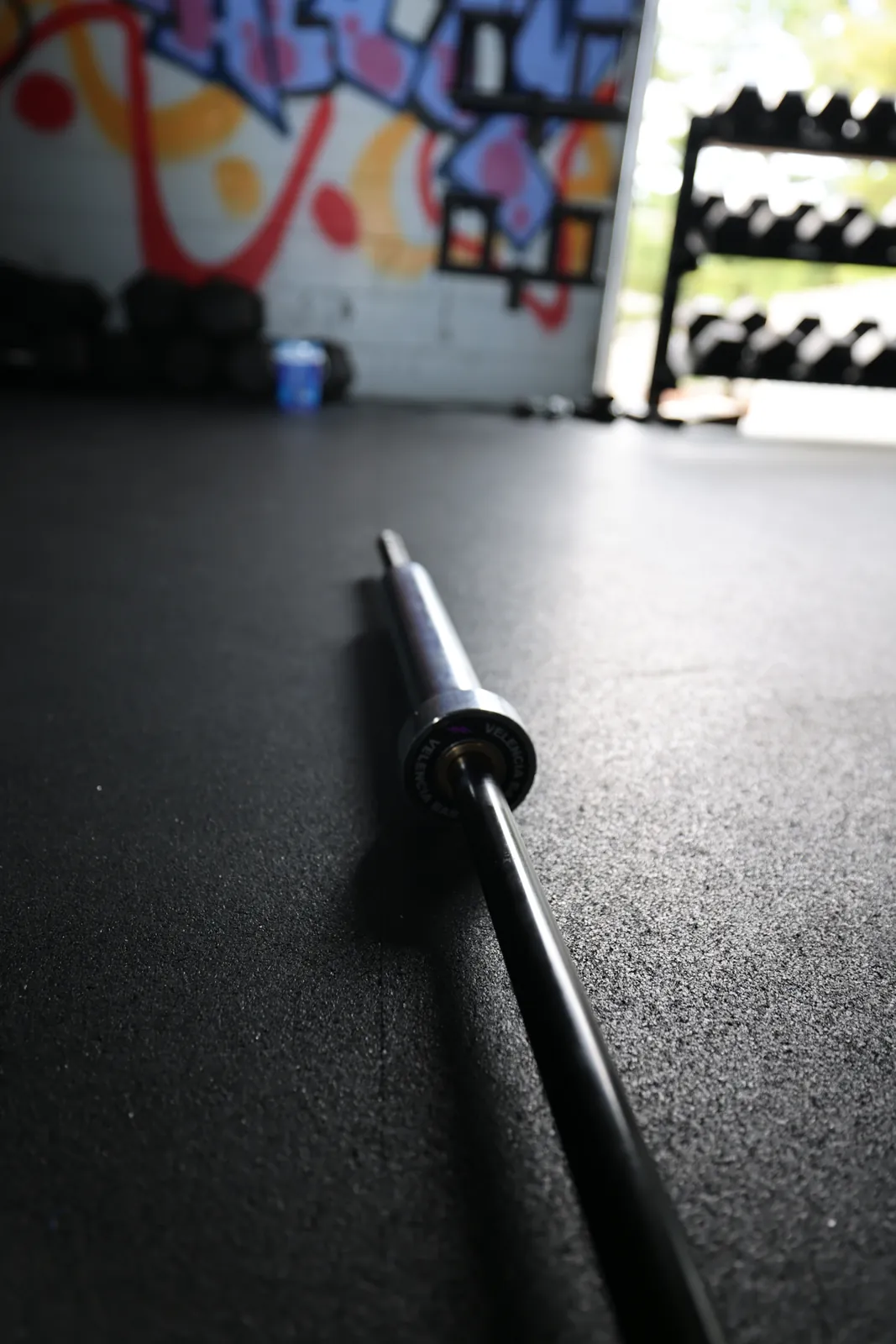 The Velencia Bar's purple-bolt end cap, with the chrome loadable sleeve and knurled grip behind it.