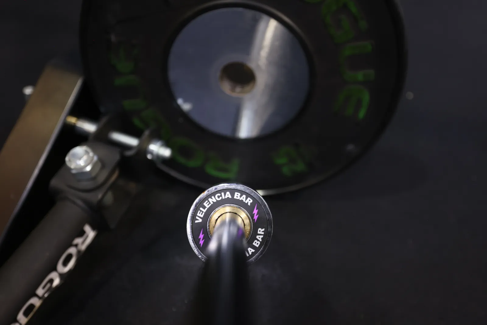 The Velencia Bar end cap, purple lightning bolts, in a landmine sleeve with a bumper plate behind it.