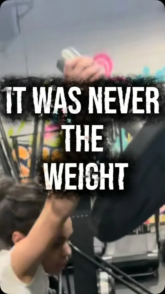 Reel cover: the words It was never the weight over a coach spotting an athlete on the bar.